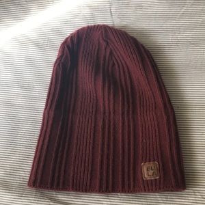 A maroon beanie and and dark green beanie